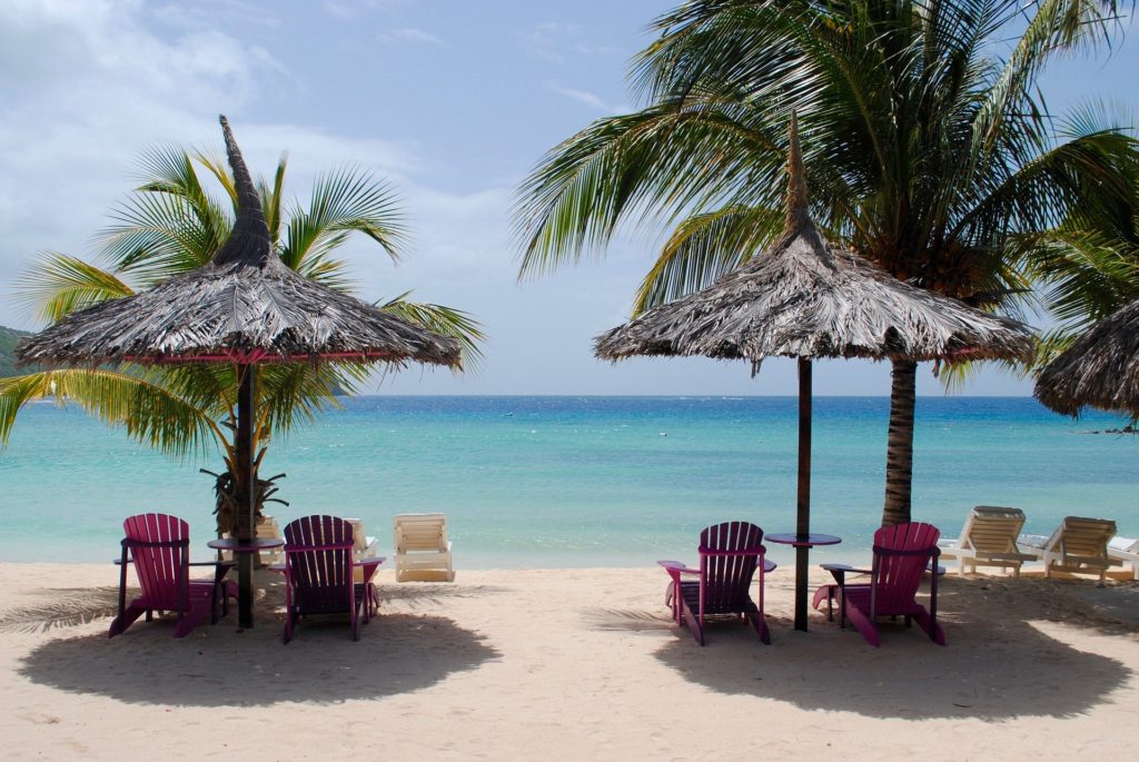 Caribbean Beach with Palm Umbrellas, Crystal Blue Waters, Sand, Palm trees, chairs and loungers